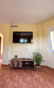 a living room with a flat screen tv on a wall at Casa Rural El Pomelo in Zurgena