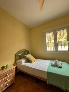 a bedroom with two beds and a dresser and two windows at Casa Rural El Pomelo in Zurgena