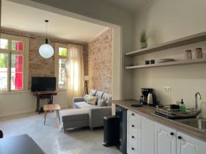 a kitchen and a living room with a couch at Sphinx Apartments - A in Chios