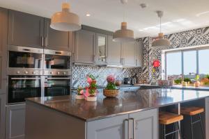 - une cuisine avec une grande île fleurie dans l'établissement 7Min to Uni Sé-Velha - AC - Work Desk - 300MBs WiFi - Suite 5, à Coimbra