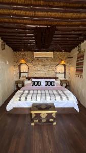 a bedroom with a large bed and a brick wall at نزل حارة المسفاة Harit AL Misfah Inn in Misfāh
