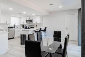 une cuisine avec une table en verre et des chaises noires dans l'établissement 5Mins to Fremont 10Mins to Strip! Sleeps 8!, à Las Vegas