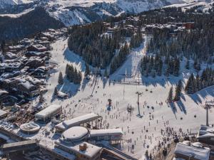 un groupe de personnes sur une piste de ski dans la neige dans l'établissement Appartement Contemporain avec Sauna, Cheminée et Parking au Centre de Courchevel 1850 - FR-1-564-35, à Courchevel