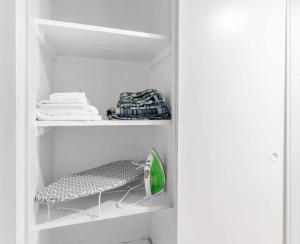 a white closet with a shelf with a vacuum at Charming Two Bedroom Sleeps 6! Close To Strip! in Las Vegas