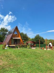 a large house with a yard with a grass field at Cabana A-frame Moon Predelut in Predeluţ