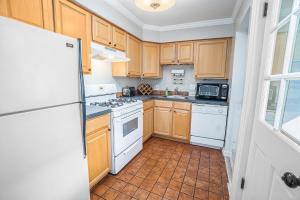 a kitchen with wooden cabinets and white appliances at Butlers Quarters in Saugatuck