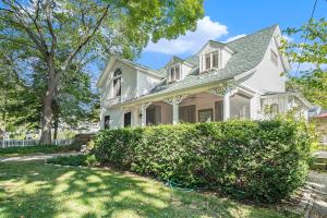 a white house with a hedge in front of it at Butlers Quarters in Saugatuck