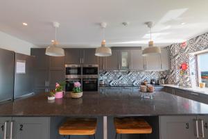 a kitchen with a large island with two bar stools at 7Min to Uni Sé-Velha - AC - Work Desk - 300MBs WiFi - Suite 3 in Coimbra +9 photos
