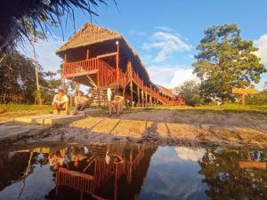a group of people sitting in front of a house at Casa Kukama Lodge in Iquitos