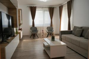 Mirandis Apartments - Modern Stays with Free Parking near Coresi Mall的电视和/或娱乐中心