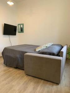 a bedroom with a bed and a couch and a television at Nuovissimo a 300 mt dalle Mura con posto auto in Lucca