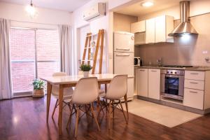 eine Küche mit Tisch und Stühlen und einem Kühlschrank in der Unterkunft Moderno y Selecto! Garage! Excelente ubicación! in Buenos Aires