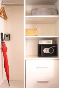 ein weißer Schrank mit einer Mikrowelle und einem Regenschirm in der Unterkunft Moderno y Selecto! Garage! Excelente ubicación! in Buenos Aires