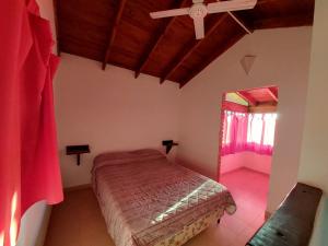 a bedroom with a bed and a ceiling fan at Un lugar en el Mundo in Villa Amancay