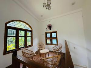 a dining room with chairs and a table and windows at Avanthika Holiday INN in Jaffna