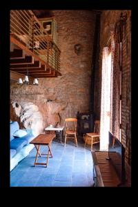 Una habitación con una mesa y sillas en una pared de ladrillos. en La Casita del Cinglo, en Obispo Hernández 20 fotos más