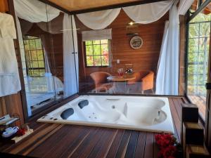 a large bath tub in a room with a table at Casa do Lago Caparaó in Pedra Menina