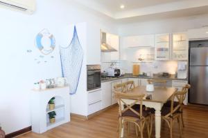 a kitchen with a table and a refrigerator at The Pool House Pattaya No.8 in Pattaya South