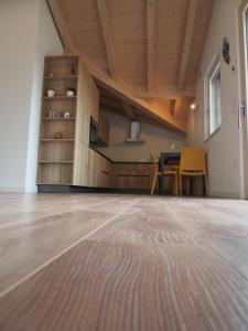 a living room with a wooden floor and a table at Casa Del Gatto Relax e Natura tra le Dolomiti in Cles