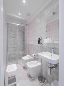 a white bathroom with a sink and a toilet at Hotel La Bussola in Finale Ligure