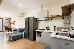 a kitchen and living room with a refrigerator and a couch at B786 Airport Apartment in Ho Chi Minh City