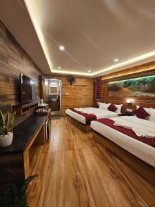 a large room with two beds and a television at S & B Dreams House in Munnar