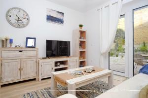 a living room with a tv and a coffee table at Uppermill Suite #3 in Pécs