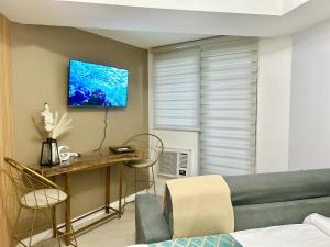 a living room with a couch and a table at Studio in Azure North Pampanga in San Fernando