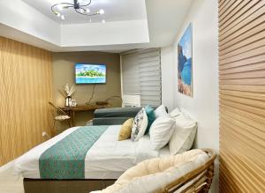 a bedroom with a bed and a tv on a wall at Studio in Azure North Pampanga in San Fernando +8 photos