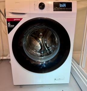 a dryer with a washing machine with its door open at Villa Utsikten Romsdalen in Åndalsnes