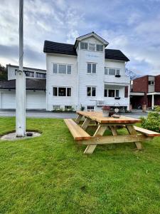a picnic table in the grass in front of a building at Villa Utsikten Romsdalen in Åndalsnes