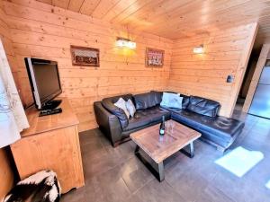 a living room with a leather couch and a table at Superbe T3 + cabine au centre des Gets, proche pistes, 7 pers, 4⭐, Wifi, équipements complets - FR-1-598-83 in Les Gets