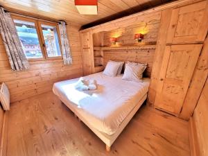 a bed in a wooden cabin with two teddy bears on it at Superbe T3 + cabine au centre des Gets, proche pistes, 7 pers, 4⭐, Wifi, équipements complets - FR-1-598-83 in Les Gets
