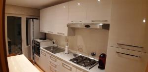 a kitchen with white cabinets and a sink and a stove at Alloggio Turistico La Perla dell'Etruria in Sutri