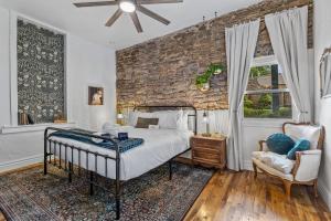 a bedroom with a bed and a brick wall at The Historic Grand Canyon Hotel in Williams