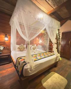 a bedroom with a bed with a canopy at Levona Garden Resort in Habarana +117 photos