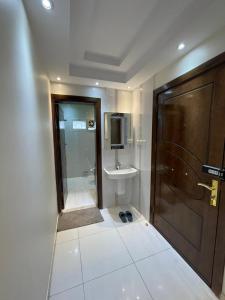 a bathroom with a shower and a sink and a door at Deluxe Furnished Apartments in Taif