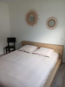 a bedroom with a bed with two mirrors on the wall at Maison 3 chambres 4 lits 6 personnes in Challans