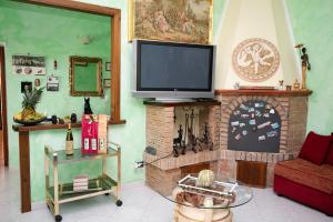 a living room with a tv on top of a brick fireplace at Casa Ragno Corchiano in Corchiano