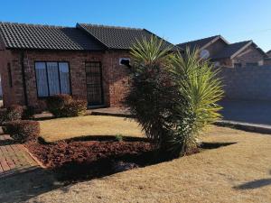 a house with two palm trees in front of it at The Lobster Z&K in Soweto