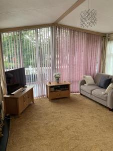 WeeleyにあるLakeside Lodge Valencia 2 bedroomのソファとテレビのあるリビングルーム