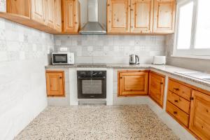 a kitchen with wooden cabinets and a stove top oven at Furnas Yoga Place in Furnas