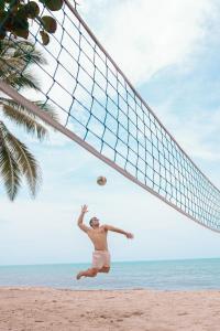 a man playing volleyball on the beach at Huku Beach Hostel Palomino in Palomino +180 photos