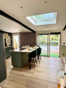 eine Küche mit einem Tisch mit Stühlen und einem Dachfenster in der Unterkunft Cosy House Near DisneyLand Paris in Roissy-en-Brie + 14 Fotos