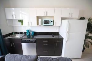 Una cocina con gabinetes blancos y un refrigerador blanco. en 2 Bedroom Apartment 3 Minute Walk to South Beach & Ocean Drive, en Miami Beach