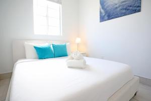 Un dormitorio con una gran cama blanca con almohadas azules. en 2 Bedroom Apartment 3 Minute Walk to South Beach & Ocean Drive, en Miami Beach