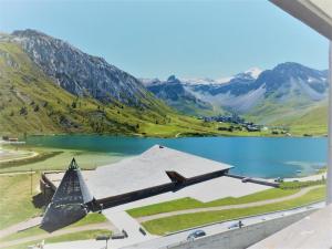 a church next to a lake with mountains in the background at Résidence Le Palafour - Studio 2 personnes à Tignes au pied des pistes, des commerces proche de l'ESF, de l'office du tourisme dans le quartier du lac. MAE-2159 in Tignes +11 photos