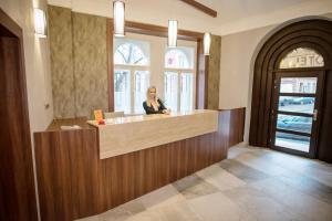 a woman sitting at a counter in a restaurant at Hotel City Bell in Prague