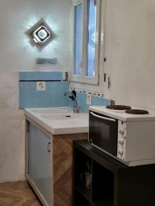a kitchen with a sink and a microwave at Spacieux appartement de 70m2 au coeur de la Patte d'Oie d'Herblay sur Seine in Montigny-lès-Cormeilles