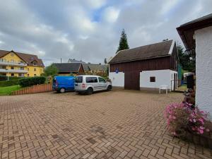 a car parked in a parking lot next to a barn at Pension Glück Auf in Brand-Erbisdorf
